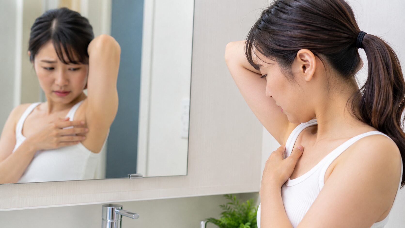 洗面所で脇の匂いを確かめる不安そうな女性